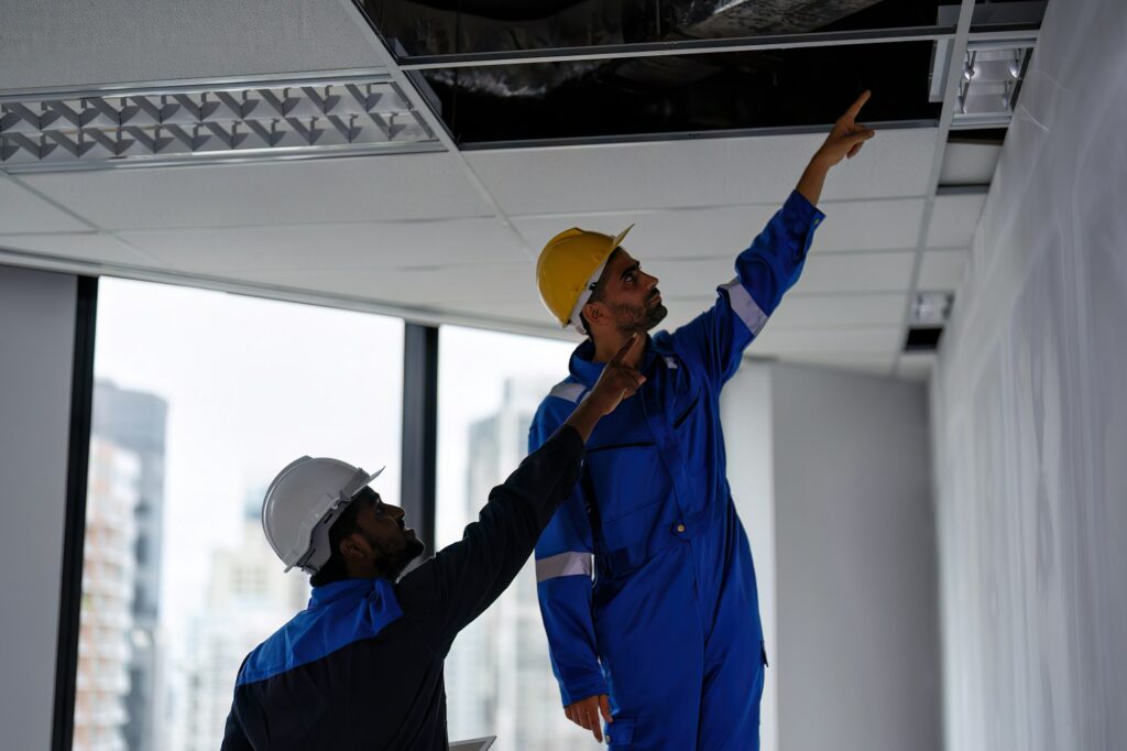 At new construction building worker open ceiling to check air condition duct on the top