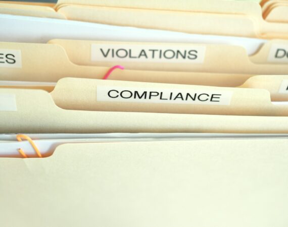 Compliance in the workplace. Folders labeled Compliance, Violations in focus.